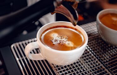 Close-up of espresso pouring from the coffee machine into a coffee cup. Professional coffee brewing,coffee crema