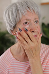 Senior woman with artsy multicolored long nails 