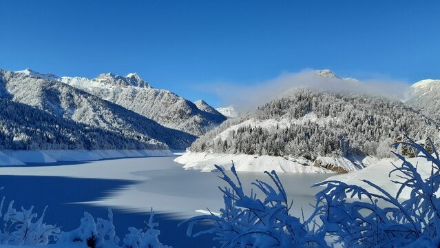 snow covered mountains on lake of sauris