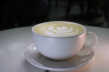 matcha drink in a white cup close-up drawing on green tea with milk beautiful serving in a...