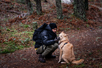 Man and loyal dog traverse snowy Sierra de Guadarrama, embracing winter adventure.