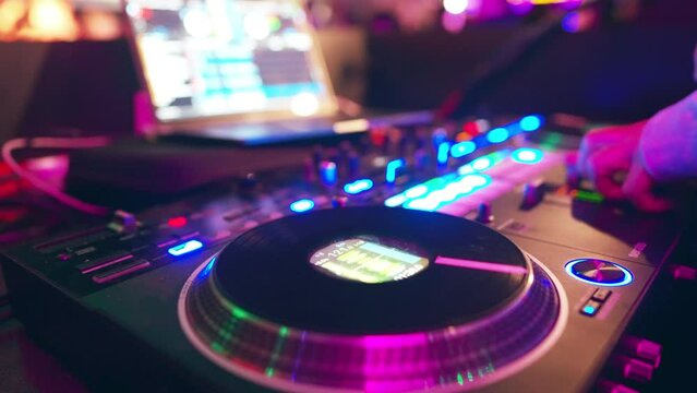dj playing on controller at nightclub, man mixing music at party with turntable emulation