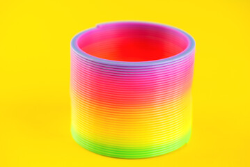Plastic rainbow, 90s toy on a yellow background.