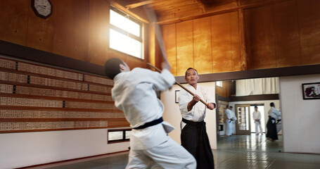 Aikido men, fight and bokken for martial arts, weapon or contest for black belt students at...