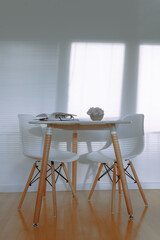 round table in interior with parquet floor and white wall