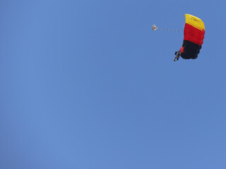 Tandem skydiving (parachuting), clear blue sky day. Parachute decorated in the Germany flag colors. Copy space.