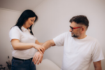 Arthritis symptoms. Doctor examining patient's hand in hospital