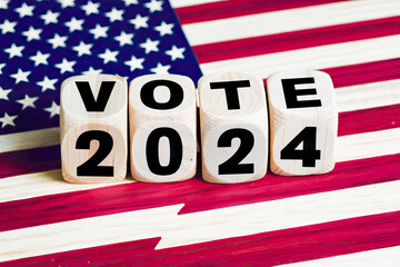 Wooden cubes with text VOTE 2024, lying on the USA flag as backdrop.United States presidential election in 2024