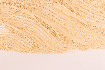 Delicate loose texture of cosmetic powder in a natural tone. Close-up view. Cosmetic background for...