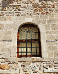 Framed windows on the stone facade of an old house
