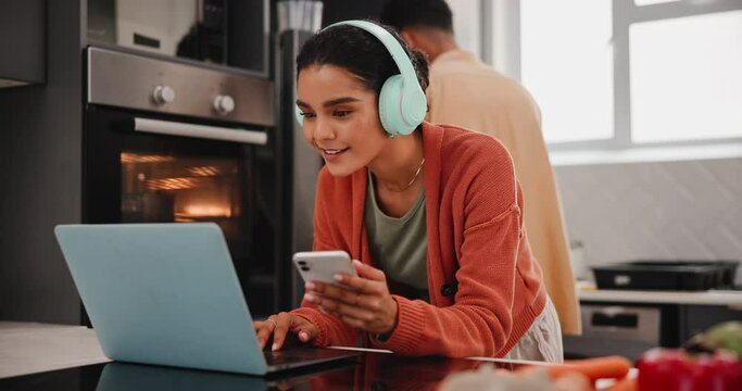 Girl, headphones and phone or laptop on kitchen table with laughing, video upload and website post. Food vlogger, gen z influencer couple and content creation with funny meal ideas and recipe in home