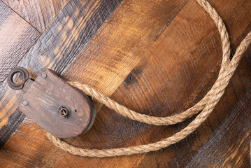 Antique block and tackle, wooden background, jute rope.
