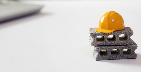 yellow worker hard hat on bricks , under contruction and wok in progress concept