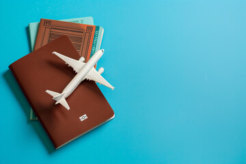 Toy airplane on top of a passport and flight booking ticket - obrazy, fototapety, plakaty