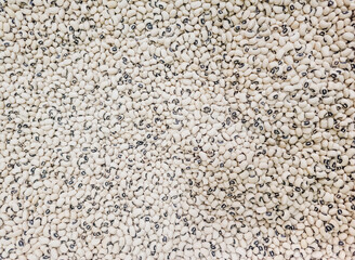 Background texture of dried black eyed beans or cowpea or peas. Top view full frame background of dried uncooked black eyed beans seeds stacked together.