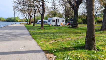 caravan car trailer by the lake grass in spring