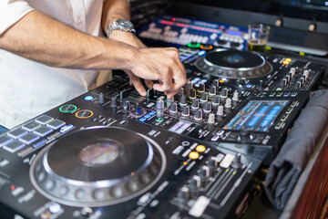 DJ's Hands Adjusting Music Mixer at Event