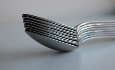 Stuck Of Same Size Silvery Spoons On Clean White Surface. Concept Photo For Table Setting Illustration - obrazy, fototapety, plakaty