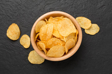 Appetizing potato chips on concrete background, top view