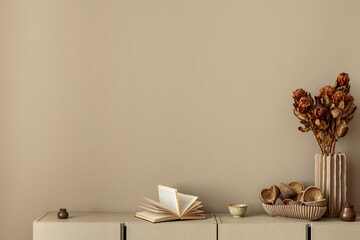 Naklejka premium Minimalist composition of living room interior with copy space, simple beige sideboard, vase with dried flowers, books and personal accessories. Home decor. Template.