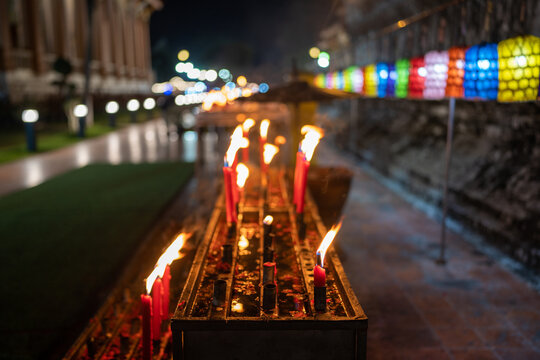 Candlelight at night at traditional Thai temple, Blur colorful lantern background.