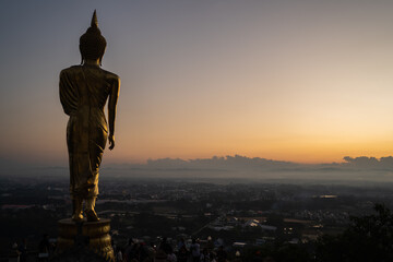 BiG golden buddha statue at Wat Phra That Khao Noi and Beautiful golden morning light, surrounding...