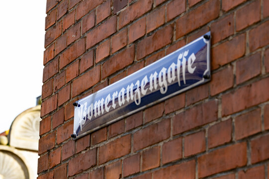 blaues Emallie Stra&szlig;enschild Pomeranzengasse in Rinteln an einer Hauswand mit roten Ziegelsteinen befestigt