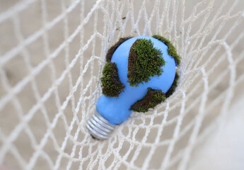social problems. Earth Day. blue light bulb with green moss entangled in networks