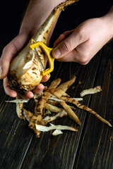Peeling beets with a vegetable peeler in the hands of a man. Preparing a vegetable dish on the...