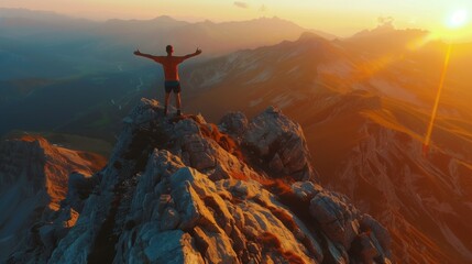 Person with open arms on a mountain peak at sunrise or sunset