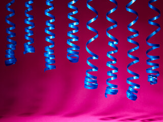 decorative blue streamer ribbon on pink background - 779790480
