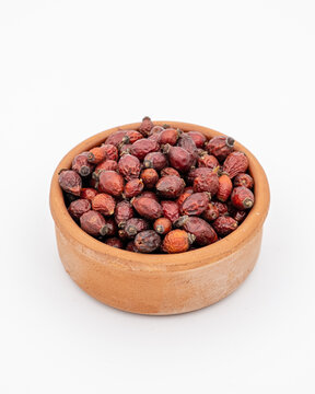 Close-up of a bowl filled with dried rosehip (itburnu) on a white background