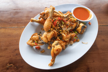 Thailand food - Fried Frog with Pepper and Garlic and fresh chilies on a white plate, served with...