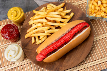 hot dog with large sausages different varieties with dressings mustard mayonnaise ketchup onion bacon cheese cucumbers and French fries