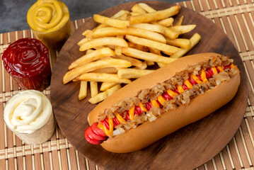 hot dog with large sausages different varieties with dressings mustard mayonnaise ketchup onion bacon cheese cucumbers and French fries