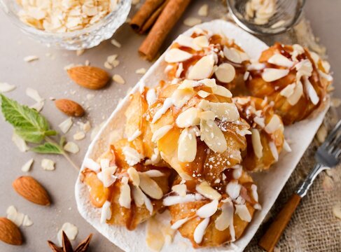 Bear claws pastry drizzled with sugar glaze and topped with almonds top view closeup