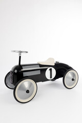 Retro style black toy car on white background. Toy car for riding in playing room. Childhood concept. - 779805686