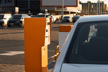 Car approaching to automatic barrier gates for supermarket parking lot. Security system for car park entry to shopping mall. Vehicle entrance with boom barriers and control tickets machine © JinOdin
