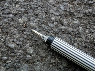 pen on asphalt background, flat lay.