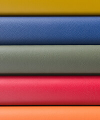 Rolls of various coloured leather ready for production in a workshop 3d render
