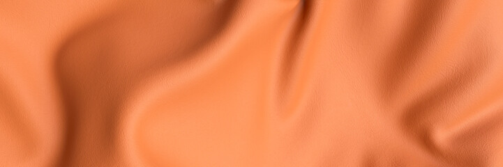 Looking down onto a piece of wrinkled orange leather close up 3d render