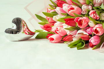 Bouquet of multi-colored tender spring tulip flowers and a shining heart. Pale soft tones soft focus.
- 779819230