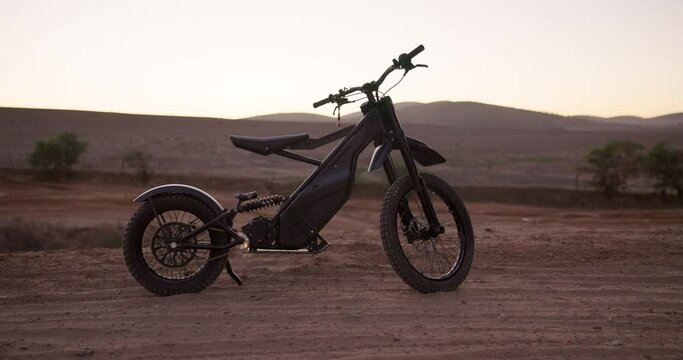 Desert, electric bike and sunset with extreme sports, challenge and competition with training and nature. Traveling, vehicle and outdoor with carbon footprint and eco friendly with sustainability