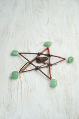 Crystal minerals, pentacle of branches and toad close up on white rustic wooden background....