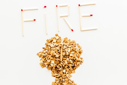 Symbol of fire in woods with tree from kindling and word fire from matches on white background top view