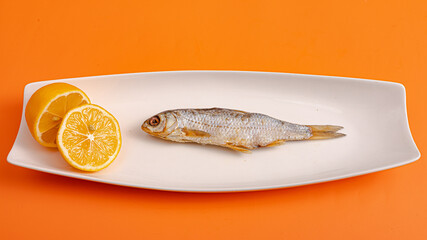 Smoked dried fish isolated on orange background