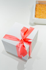 Gift-Ready Delight: A Cake in Its Box with a Scrumptious Sponge Cake Beside