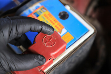 Hand checking  on battery in anode of car engine in using