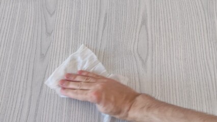 Man wipes table with wet napkin