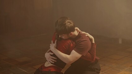 Professional dancers performing dance show. Young man and woman contemporary dancers perform modern choreography elements in smoke, middle shot.